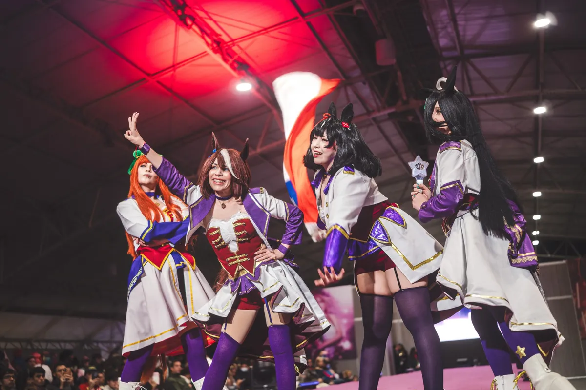 Cuatro cosplayers de Umamusume con trajes de presentación posando en la pasarela de SOFA
